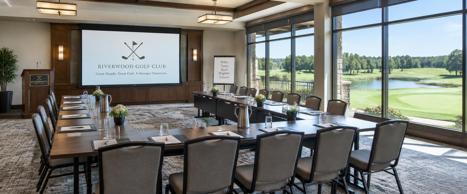 A bright clubhouse meeting room with tables set for a group and windows overlooking the golf course